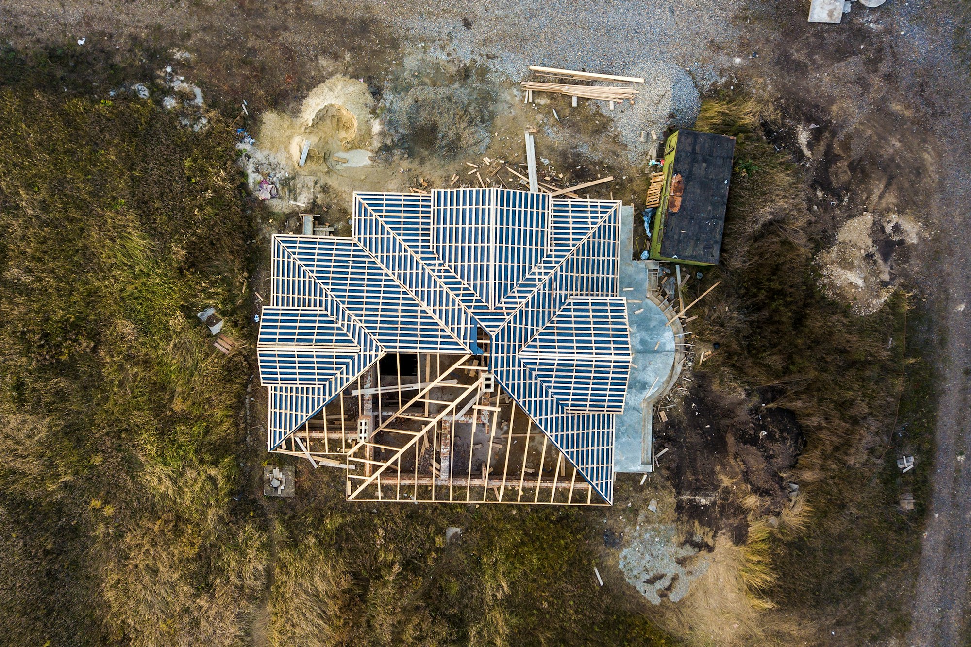 Private residential house with wooden roof frame structure under construction.