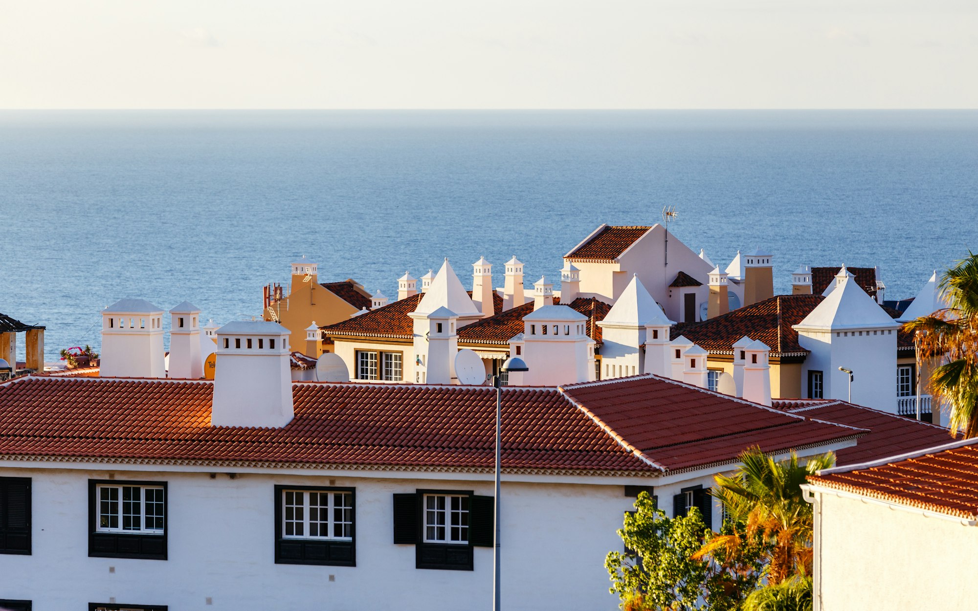 Red roofs and white chimneys of the small european town near the sea